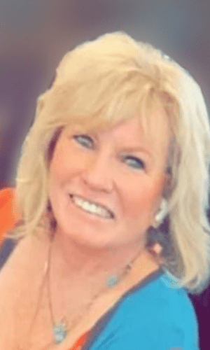 Smiling woman with blonde hair in a close-up portrait.